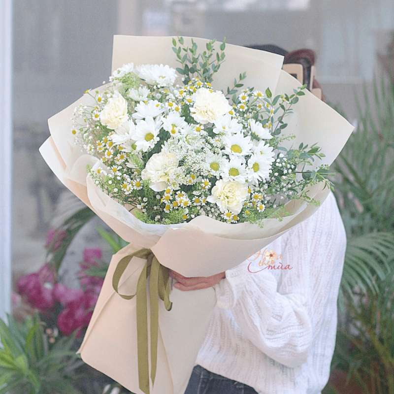 Một bó hoa sinh nhật cho nữ được gói ghém tinh tế, đặt kèm theo một tấm thiệp nhỏ viết tay, thể hiện sự chu đáo và tình cảm chân thành của người tặng.